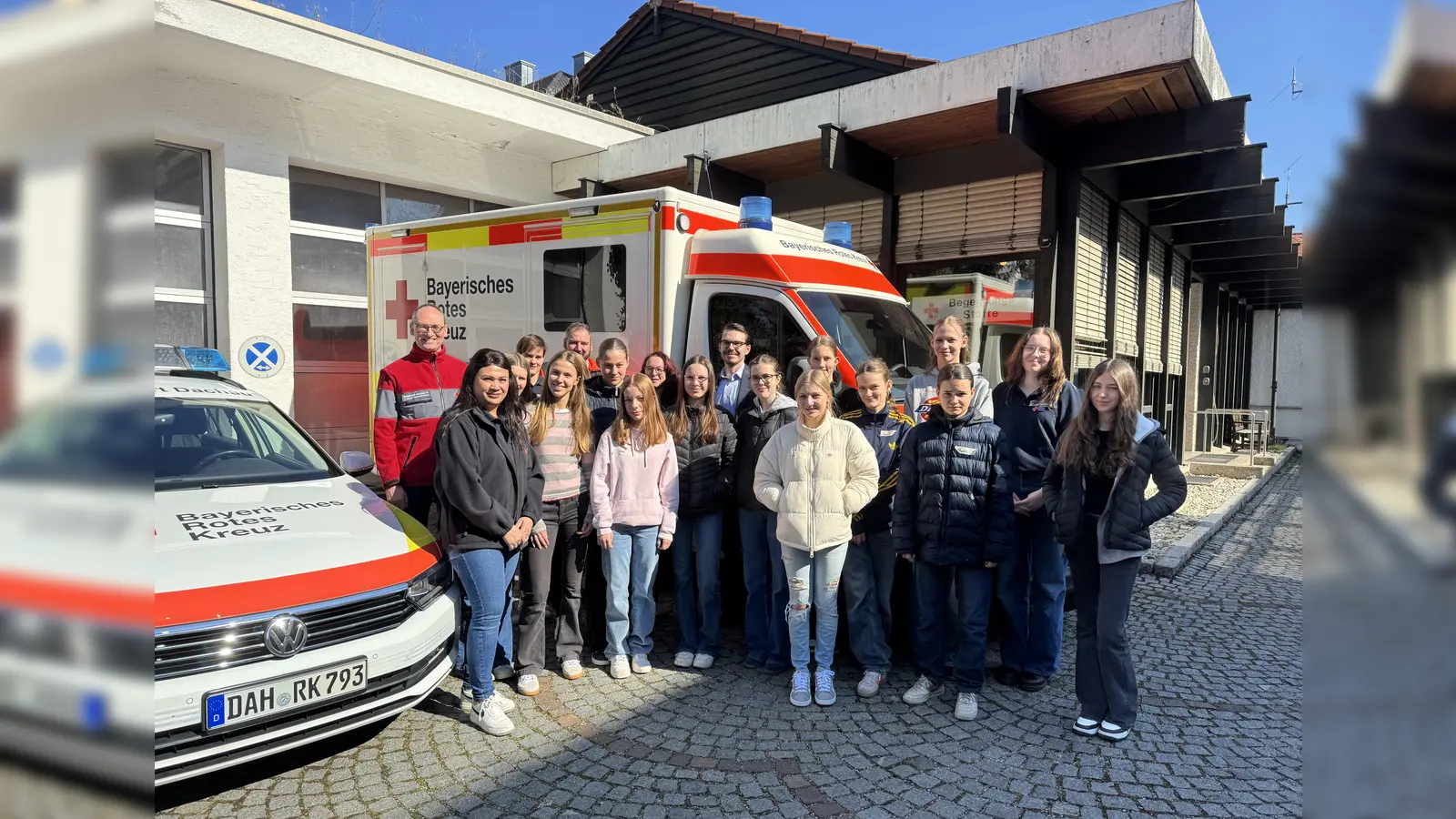 Bernhard Seidenath (l.), stellvertretende Personalleiterin Diana Tielman (2. v. l.), Dennis Behrendt (hinten Mitte) mit den Schülerinnen am im BRK. (Foto: BRK - Kreisverband Dachau)