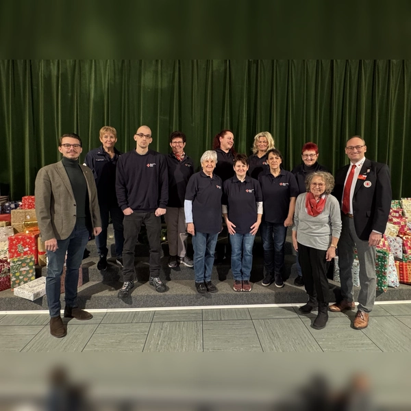 Die Geschenke warteten darauf beschert zu werden. Dennis Behrendt, Angelika Gumowski und Stefan Tezner mit dem ehrenamtlichen Team sowie Bernhard Seidenath (rechts).<br>  (Foto: BRK)