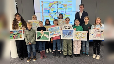 Stolz präsentieren die Kinder und Jugendlichen den Jugendmalkalender 2024, hinten Bankvorstand Klaus Berger. (Foto: VR-Bank)