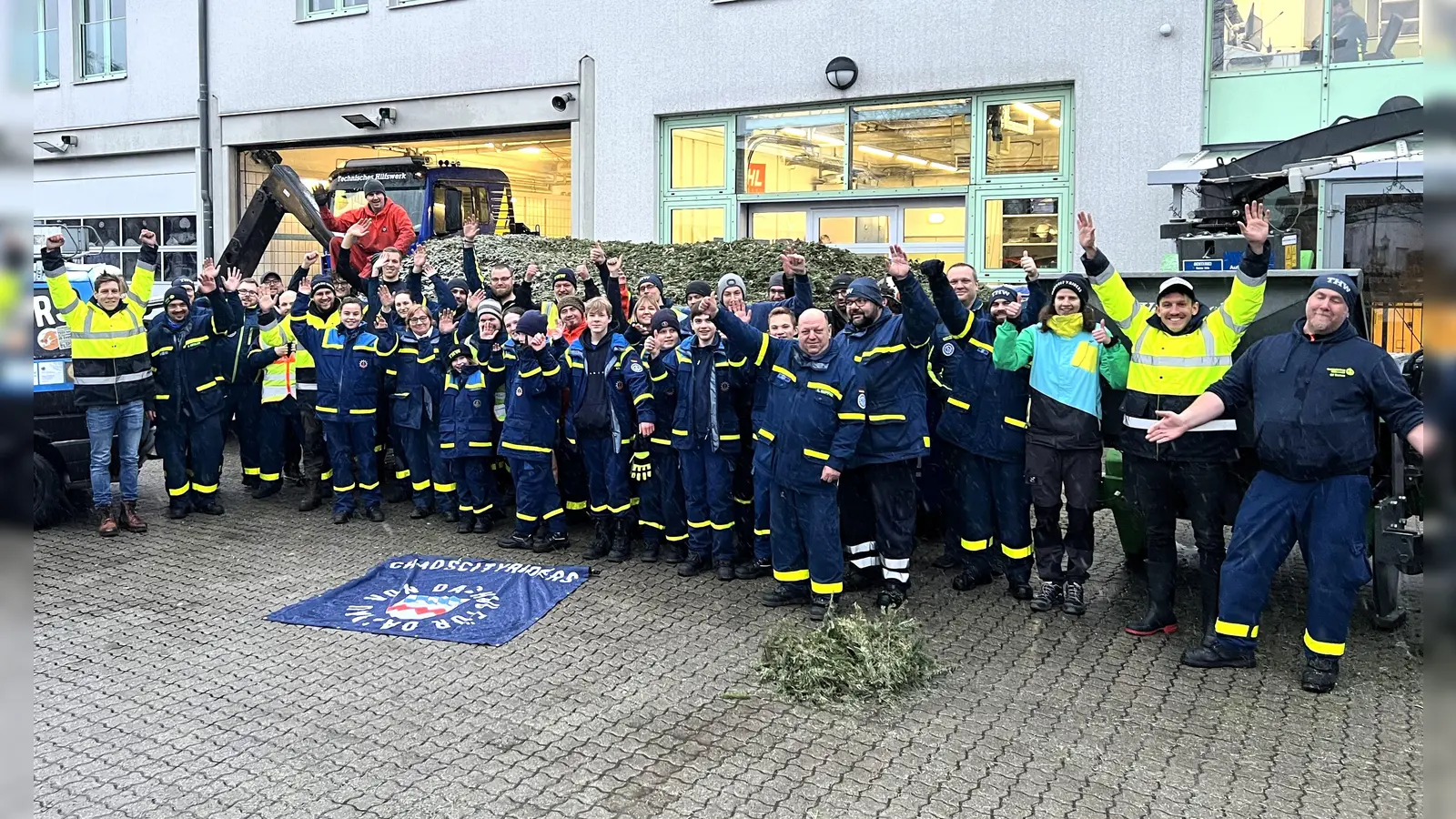 Die Helfer auf dem Gelände des THW, im Hintergrund der Container mit den zu Hackschnitzel verarbeiteten Bäumen. (Foto: Miriam Kohr)