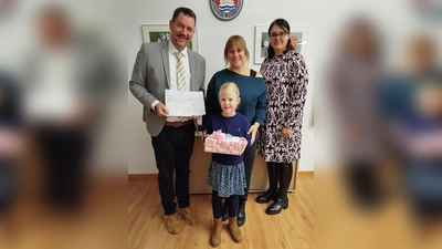 Die siebenjährige Hanna Pache aus Feldgeding erhielt von Bürgermeister Robert Axtner ein Geschenk.. (Foto: Gem)
