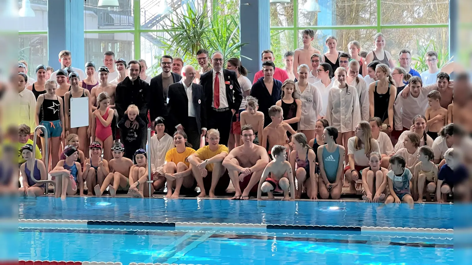 Max Frisch, Dennis Behrendt, Jörg Westermair und Bernhard Seidenath (von li) umringt von den Schwimmerinnen und Schwimmern vor dem Wettkampf. (Foto: BRK Dachau)