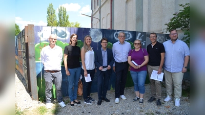Vor dem Bauzaunprojekt (von li): Michael Gerstner (Isaria), Martina Reuter (Isaria), Anika Strobel (Isaria), Florian Hartmann, David Christmann (Isaria), Katja Graßl, Markus Erhorn und Tobias Stephan. (Foto: Isaria)